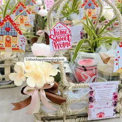 This detailed shot highlights the contents of a housewarming favor, including a small plant, a scented candle, and a beautifully tied ribbon.