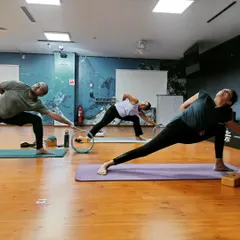 Students using the yoga wheel as a guide in this extended side angle pose variation. Props are wonderful tools to explore alignment and find more space in the body.