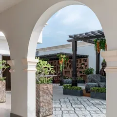 We transformed this empty rooftop into a serene escape. This view, framed by classic arches, showcases the custom pergola, intricate tilework, and lush planters that create a perfect oasis for relaxation and entertainment right at home.