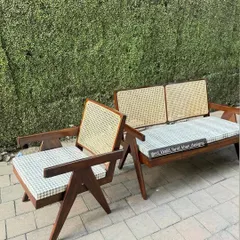 A full living room set based on the iconic Pierre Jeanneret V-leg design, including a two-seater sofa and matching lounge chairs.