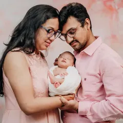 A quiet, intimate moment for new parents. They hold their newborn together, their heads touching, in a pose that speaks of their love and partnership in this new chapter.