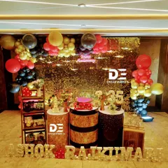 A glamorous 35th-anniversary party featuring a stunning gold sequin backdrop, a 'Happy Anniversary' neon sign, and a bold red, black, and gold balloon arrangement.