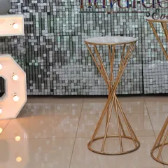 Elegant spiral pedestals used in an anniversary setup, perfect for holding a cake, champagne, or photos.