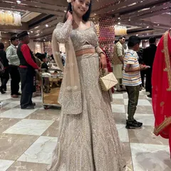 This happy client is all smiles in a shimmering silver-grey lehenga. It's a sophisticated and glamorous choice for a wedding guest or bridesmaid.