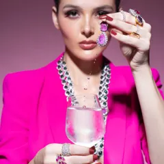 A conceptual beauty shot for a jewellery campaign. The bold pink blazer and creative use of water create a modern, artistic context for the precious stones, showing that jewellery styling can be highly imaginative.
