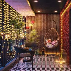 This city balcony becomes a magical retreat at night with a canopy of fairy lights. We used patterned floor tiles, a comfortable swing chair, and brick-textured walls to create a bohemian-inspired space perfect for enjoying the evening view.