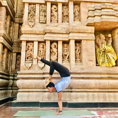 In this scorpion handstand, touching the foot to the head symbolizes enlightenment. Practicing in front of this ancient temple adds a layer of history and devotion.
