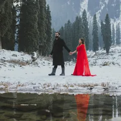 To showcase my destination wedding photography, I took this couple to the snowy landscapes of Kashmir. The striking contrast between the bride's flowing red gown and the pristine white snow creates a visually arresting image that tells a story of adventurous love.