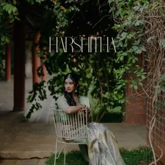 A serene portrait of the bride-to-be, seated in a garden setting. The natural light and lush green background create a peaceful and elegant mood for this engagement photo.