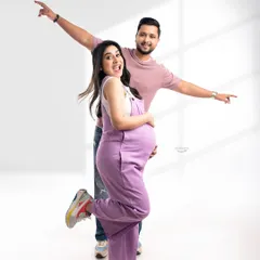 Capturing the fun and excitement of pregnancy with a playful pose. This couple's joyful energy is infectious, and the casual outfits show a different, more relaxed side of maternity photography.