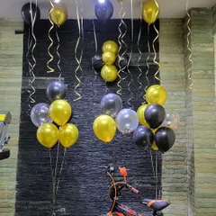 Helium balloon bunches in black, gold, and transparent confetti, perfect for decorating a corner of a room.