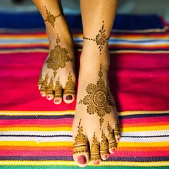 This elegant foot design features a central mandala with a delicate chain connecting to an ankle band.