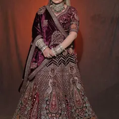 A bride styled in our heavily embroidered wine-colored velvet lehenga. These portraits are a perfect example of a classic bridal look for any MUA's book.