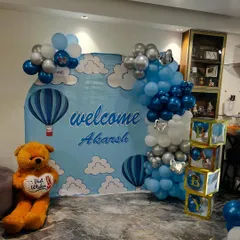 The main backdrop for welcoming baby Akarsh, featuring a hot air balloon theme, a balloon arch, and 'BABY' blocks.