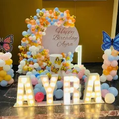 A stunning butterfly-themed first birthday for Ayra. We used large light-up letters for the name as a centerpiece, surrounded by a colorful pastel balloon arrangement and butterfly accents.