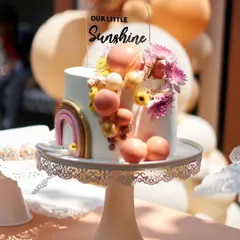 A close-up of a "Little Sunshine" cake, decorated with a rainbow and colorful spheres, perfectly capturing a bright and happy theme.