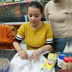 A student carefully crafting a design using air-dry clay. Our "Blue Paradise" workshop focuses on creating intricate clay relief art.
