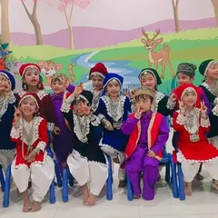 The complete group of New Horizon Kids in their traditional Kashmiri outfits, showing the vibrant mix of colors and detailed embroidery in each costume.