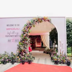 The grand entrance for the Bangalore Wedding Fraternity meetup. A lush floral arch and red carpet created a spectacular welcome for over 500 industry professionals.