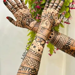This heavy bridal back of hand design is rich with detail. It features personalized initials and intricate geometric and floral patterns, creating a full and luxurious look.
