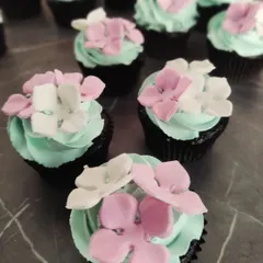 Delicate floral cupcakes with handcrafted sugar flowers. These are perfect for elegant corporate events, product launches, or special celebrations like Women's Day.