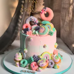 Welcome to Candyland! This tall, whimsical cake is loaded with pastel donuts, rainbows, and candy swirls, creating a party in itself for a sweet celebration.