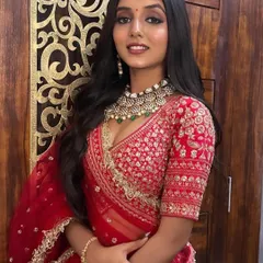 A closer look at our classic red bridal lehenga. The intricate gold embroidery on the blouse and the sheer net dupatta with a detailed border create a look of pure elegance.