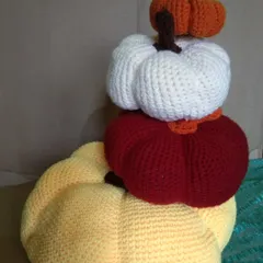 A stack of my handmade crochet pumpkins in various fall colors. These amigurumi props are perfect for autumn-themed photoshoots, adding a cozy, harvest feel.