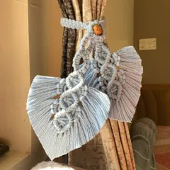 Our macrame curtain holders are a beautiful way to style your drapes. This design features intricate knots and a leaf shape, adding a touch of boho charm to your windows.
