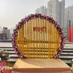 This is a classic Haldi ceremony backdrop we created for an outdoor pre-wedding function. The design features a circular frame decorated with marigold garlands and a border of pink and white roses for a traditional yet fresh look.