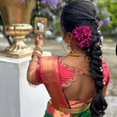 The bride admiring her final look. The combination of a perfectly draped saree, traditional jewelry, and a beautiful hairstyle creates a timeless and elegant appearance.