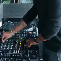 A close up showing my hands working the mixer. My experience allows me to manipulate the sound in real time, adding effects and layers to make each set unique.