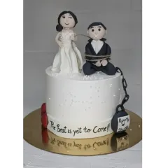 A playful cake for a bride and groom to be. This choco-vanilla cake features funny, handmade fondant toppers showing the bride has "captured" her groom.