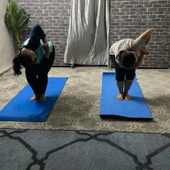In this personal training session, I am guiding a student through a standing side bend and twist, focusing on balance and spinal mobility.