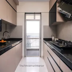 This sleek and modern parallel kitchen is designed to maximize space and functionality. It features matte beige cabinetry, black granite countertops, and a clean, minimalist aesthetic that feels bright and contemporary.