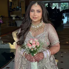 A fresh day-bride all the way from Dubai for her sundowner wedding in Jaipur. Her makeup is soft and radiant, paired with a simple bouquet of pink and white roses for a touch of romance.