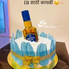 'IB saathi kaybi!' A fun cake for a whiskey lover, designed to look like a bottle of Imperial Blue chilling on ice. The 'ice' is created with blue and white frosting effects.