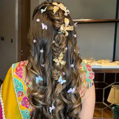 A different angle of the butterfly-adorned half-up style, showing the placement of the clips and the texture of the curls.