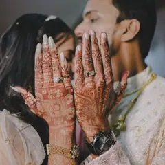 A creative shot showcasing the couple's hands with their intricate henna designs and new engagement rings.