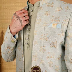 Where custom becomes classic. A detailed shot of a light green Indo-Western jacket, highlighting the fabric's floral pattern and the kurta's button placket.