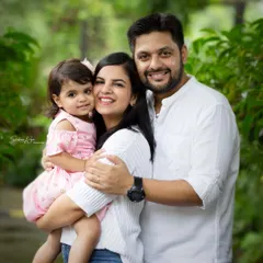 A classic family hug against a lush green background. This portrait shows the warm and loving connection of this beautiful family during their outdoor session.