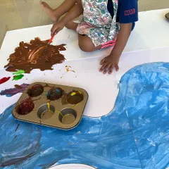 Who needs a regular palette? We encourage using everyday objects, like this muffin tin, to explore paint. This approach sparks curiosity and teaches children that art can be found and made with anything around them.