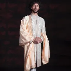 This is my vision of a modern groom's sherwani. It blends classic charm with a clean, minimalist grace, featuring fine, all-over embroidery on a structured silhouette. The ensemble is completed with a pure silk stole, creating a look of refinement without being loud.