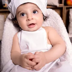 A delightful close-up of our little chef, capturing a moment of curiosity and wonder. These expressive shots are a beautiful part of any themed baby photoshoot.