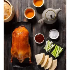 A whole Peking Duck, expertly roasted and presented for the new menu at Shang Palace. This overhead shot captures the full presentation with pancakes, sauces, and garnishes.