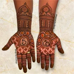 A lovely engagement mehendi with the initial 'S' and a symbol of rings. The design is filled with traditional elephant and floral patterns.