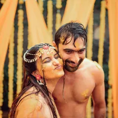 A sweet and candid moment between the couple during their Haldi ceremony, with the bride playfully smearing turmeric on the groom.