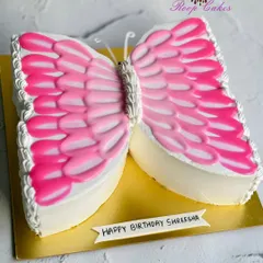A beautiful butterfly-shaped cake for Shreesha's birthday. The wings are decorated with piped pink and white frosting, creating a delicate and fluttery design perfect for a girl's celebration.