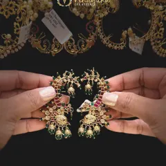 These celebrity-style earcuffs feature a beautiful peacock design with ruby and emerald colored stones and tiny jhumki drops. They are perfect for making a fashion statement.