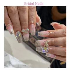 For our brides, we create unforgettable nail art. This design features long, square-shaped extensions with a glitter base, sparkling rhinestones, and delicate 3D bow embellishments for a truly special day.